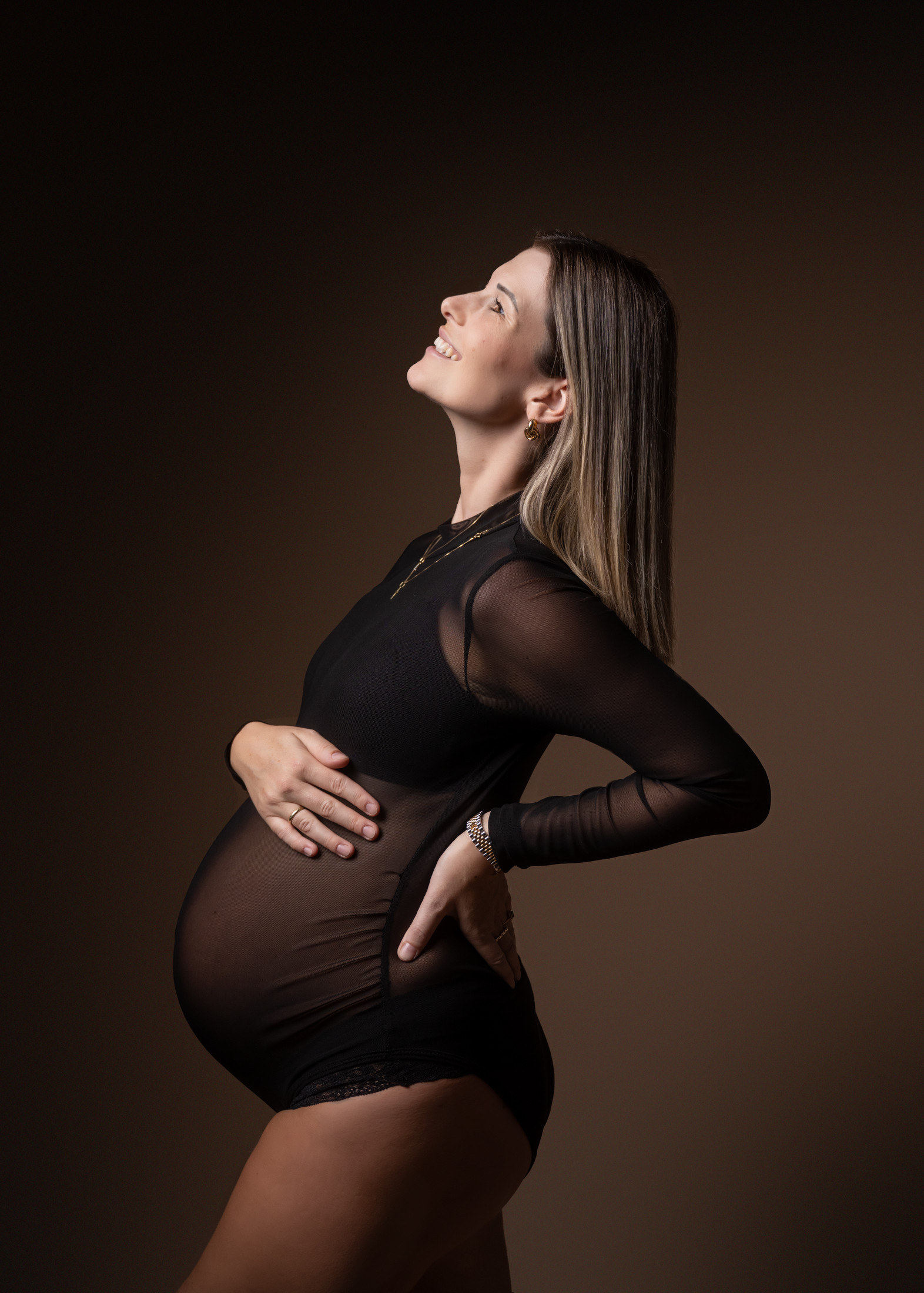 Schwangere im Mesh-Bodysuit, Blick nach oben, Studiolicht