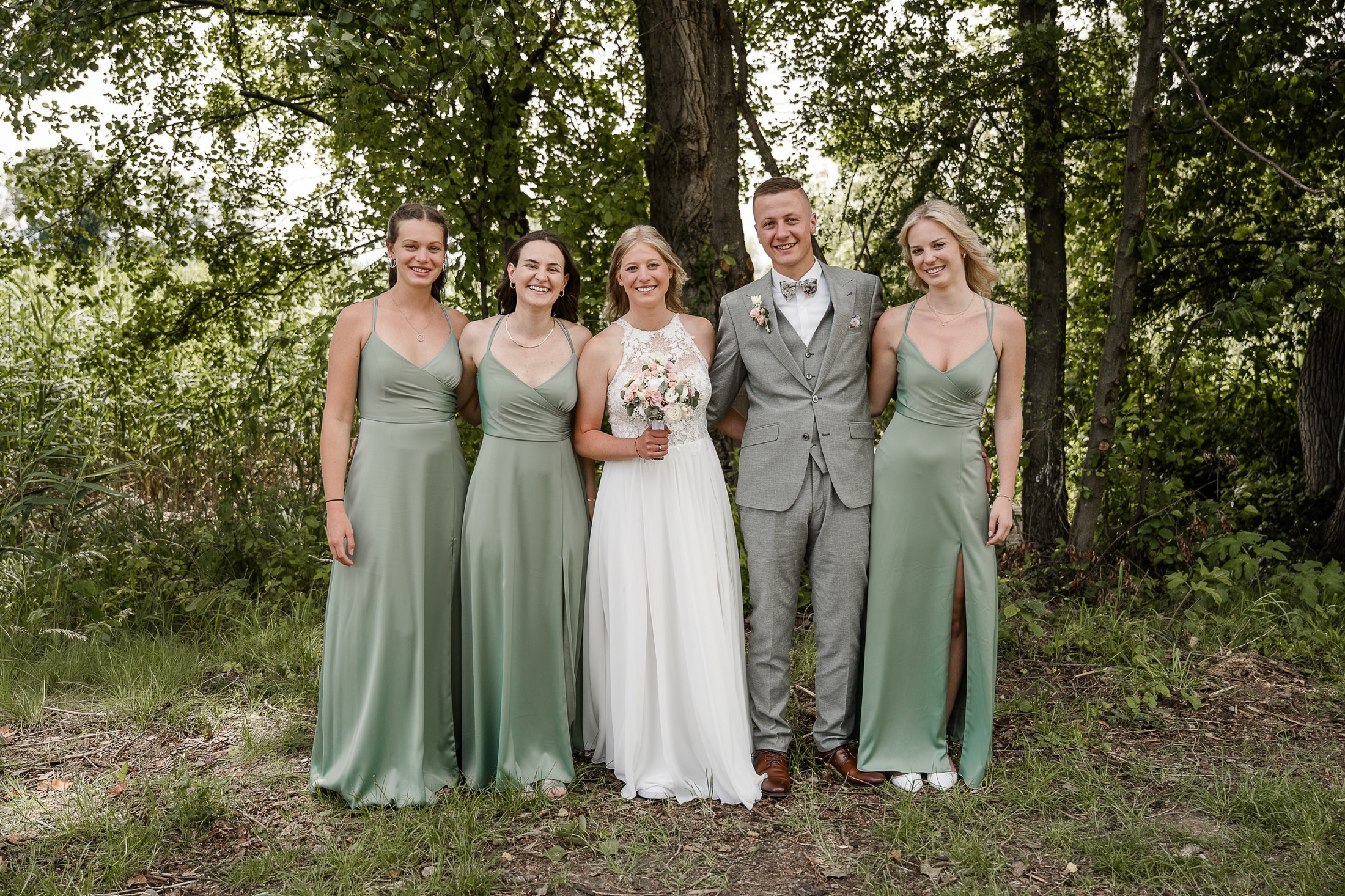Brautpaar mit Brautjungfern im Wald