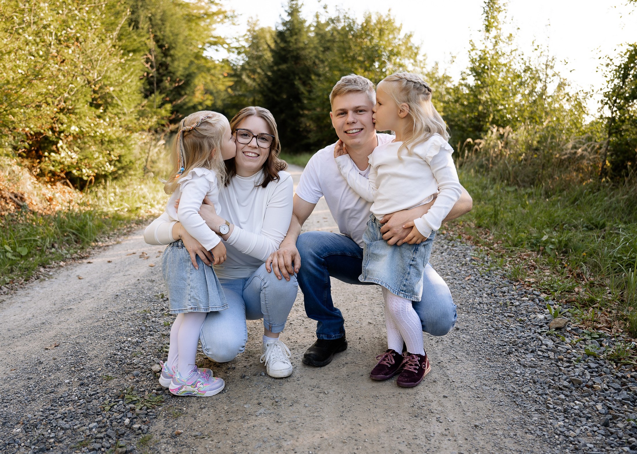 Familie küsst sich auf dem Waldweg