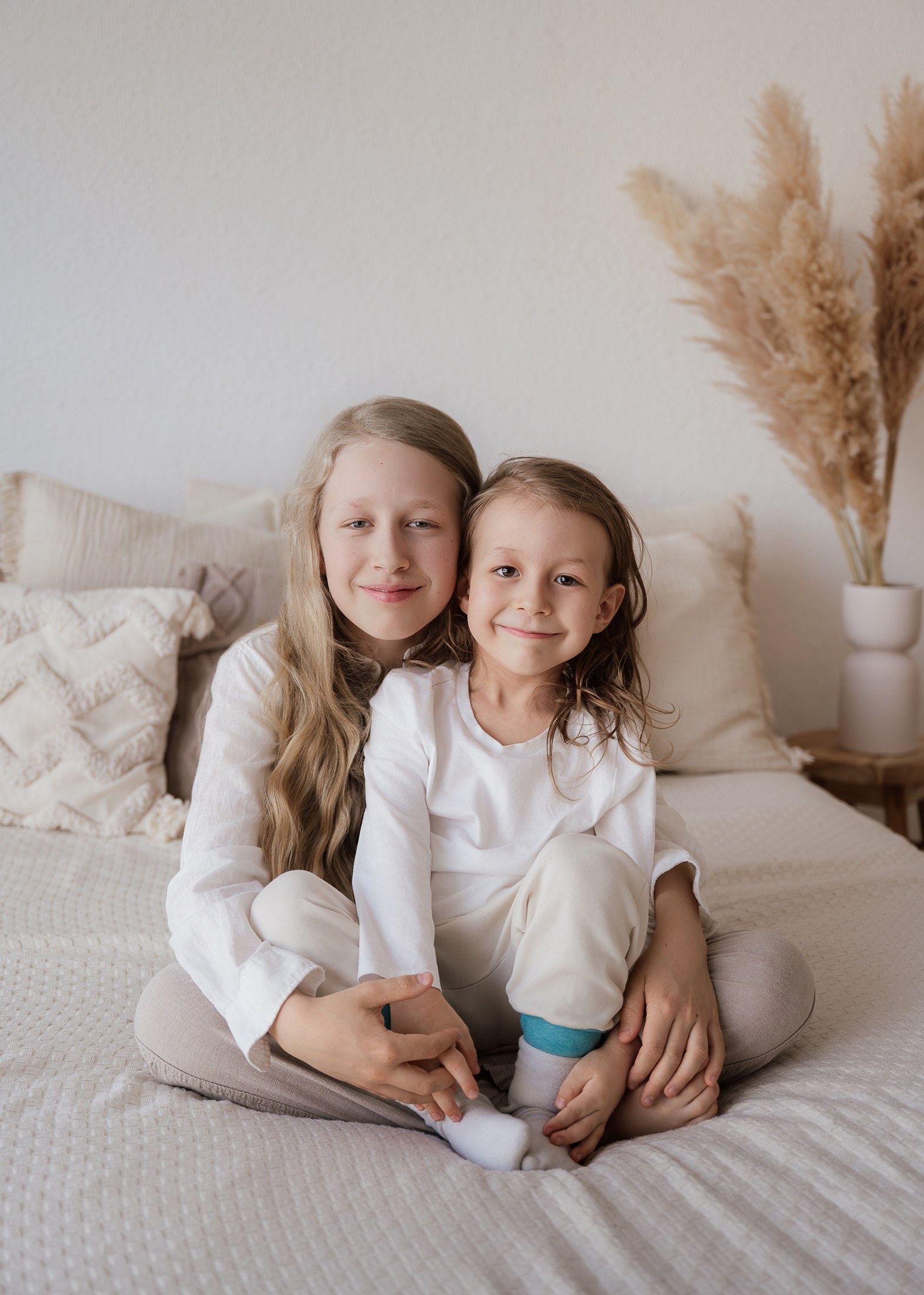 Geschwister kuscheln auf dem Bett
