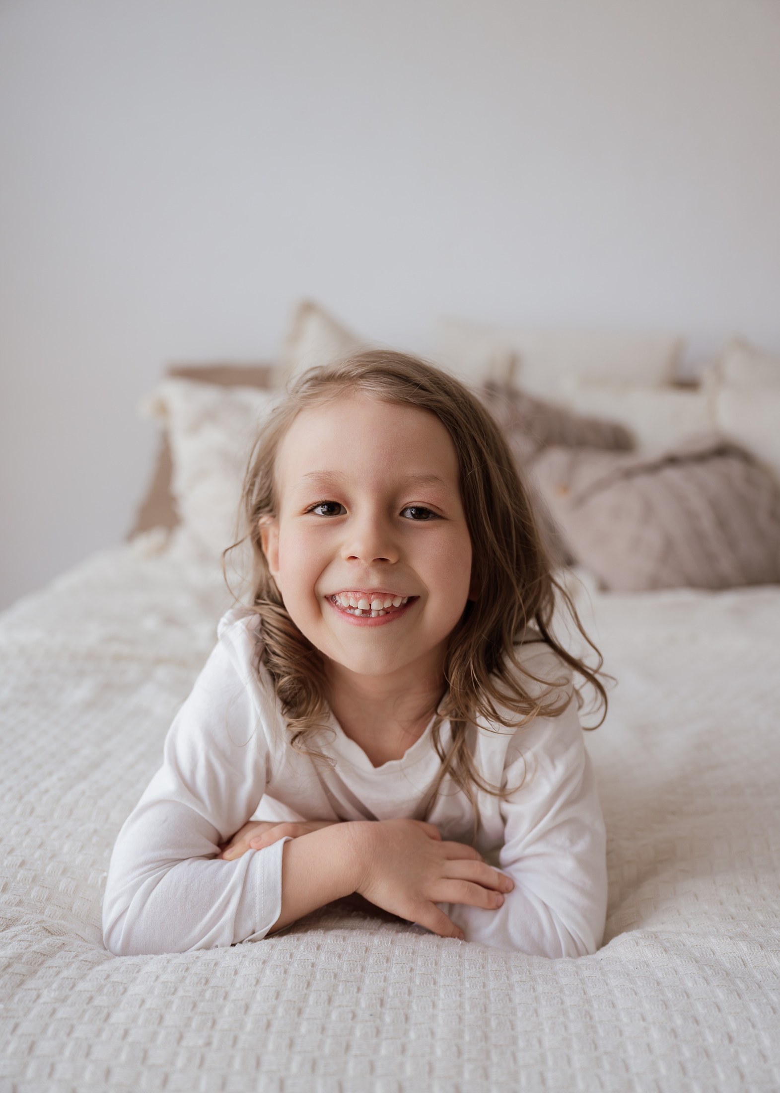 Kleines Mädchen lächelt auf dem Bett