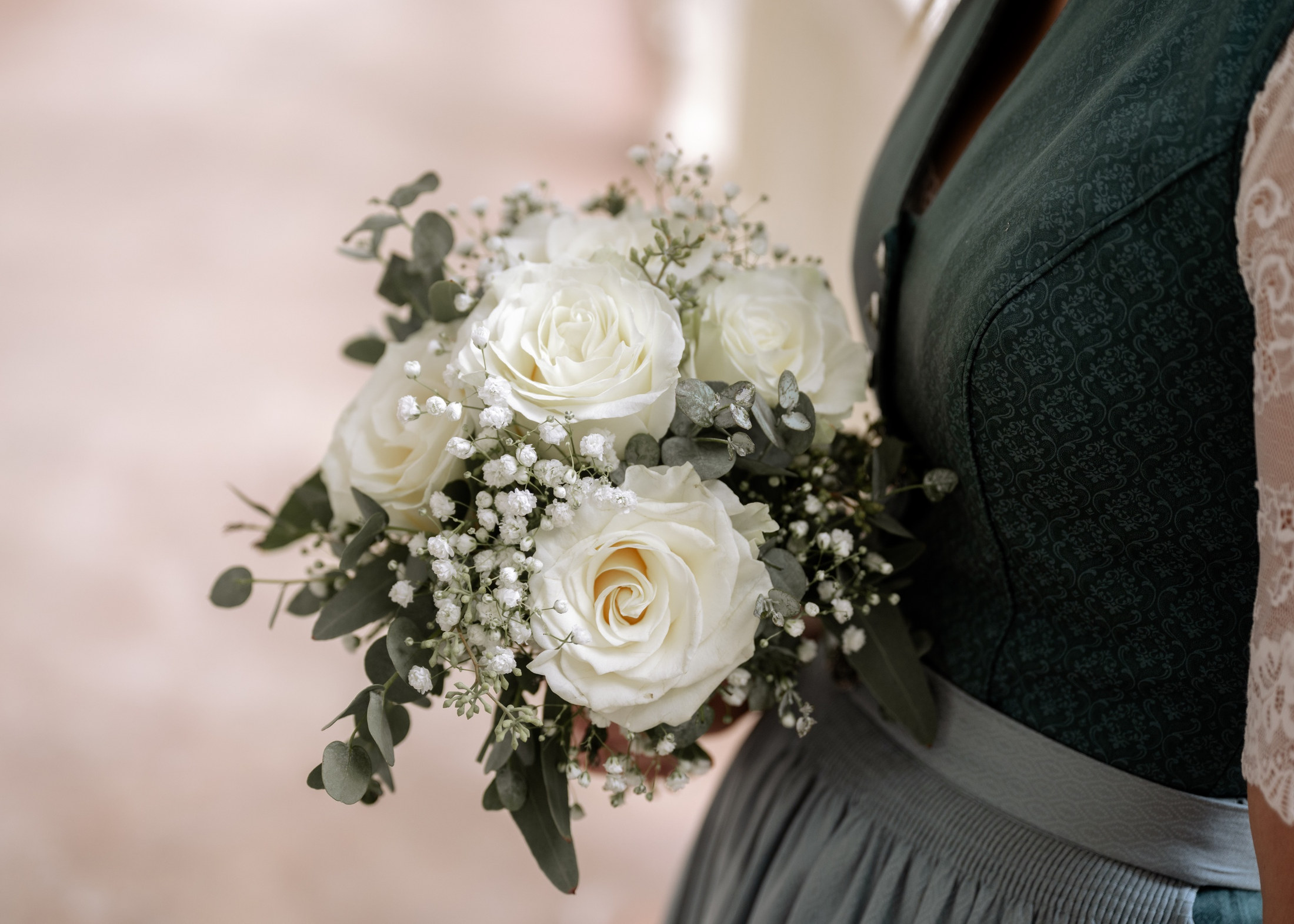 Nahaufnahme eines Brautstraußes mit weißen Rosen und Eukalyptus