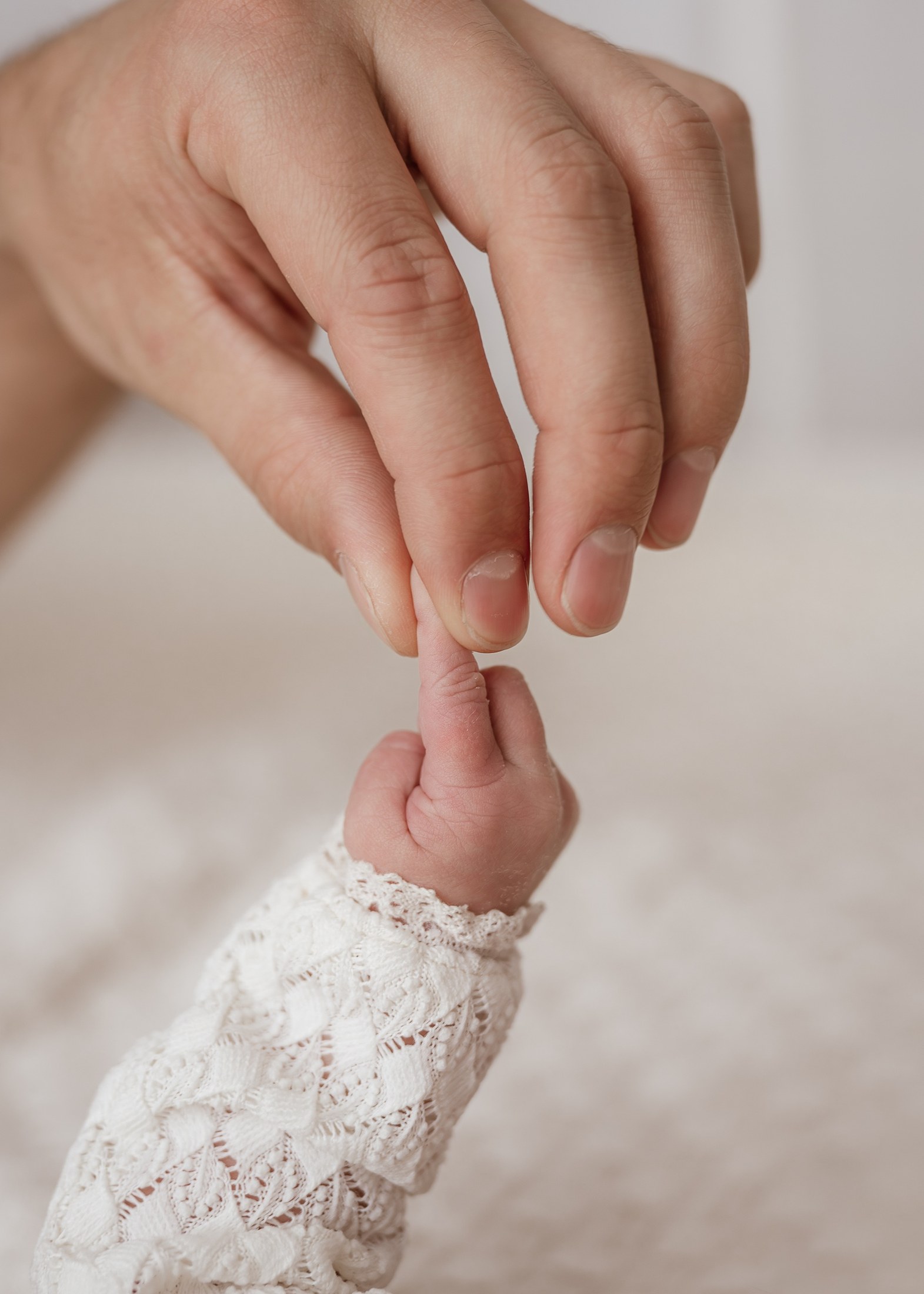 Neugeborenenhand greift nach dem Finger des Vaters
