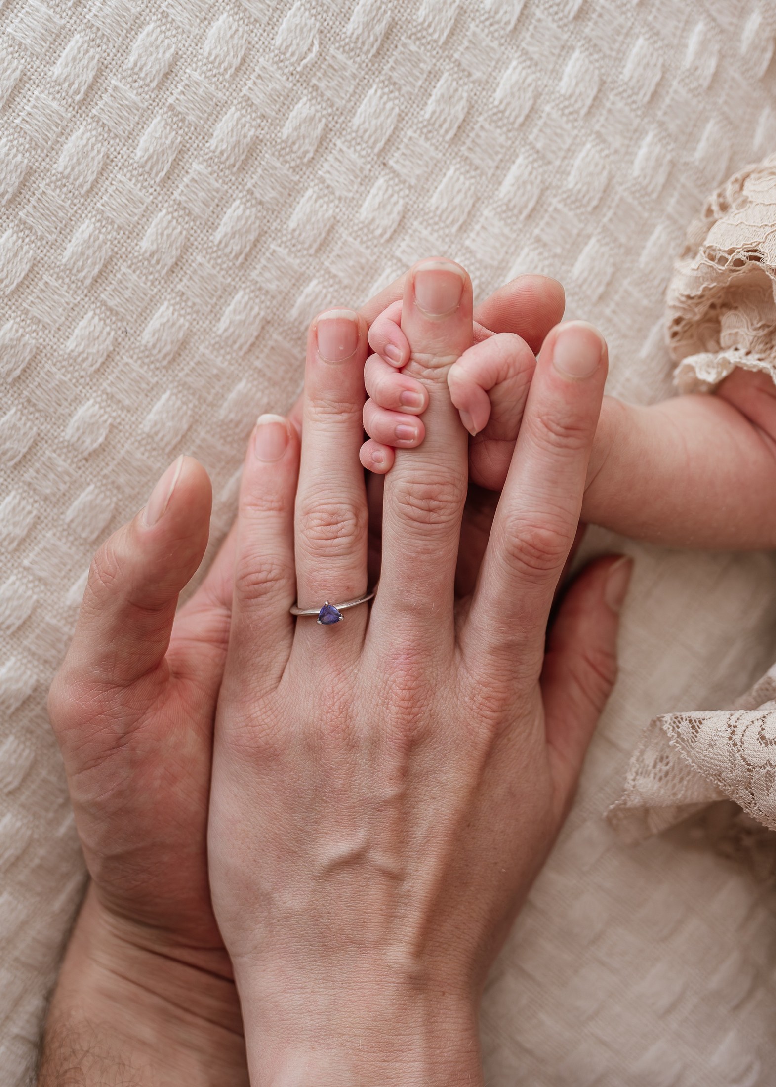 Babyhand umschließt den Finger der Mutter
