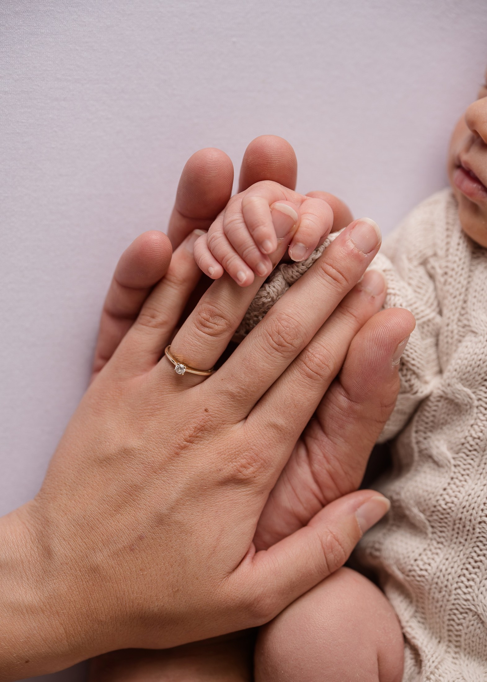 Babyhand in den Händen der Eltern
