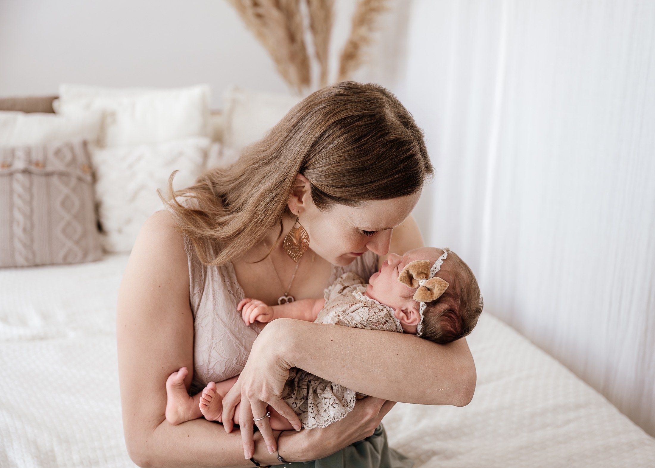 Mutter berührt mit der Nase ihr neugeborenes Baby