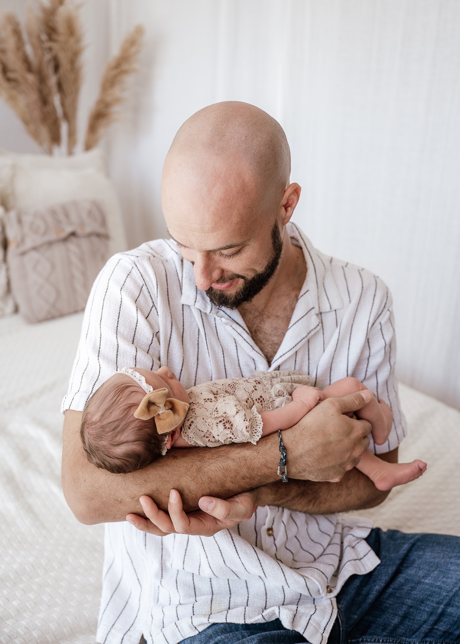 Vater hält sein neugeborenes Mädchen lächelnd im Arm
