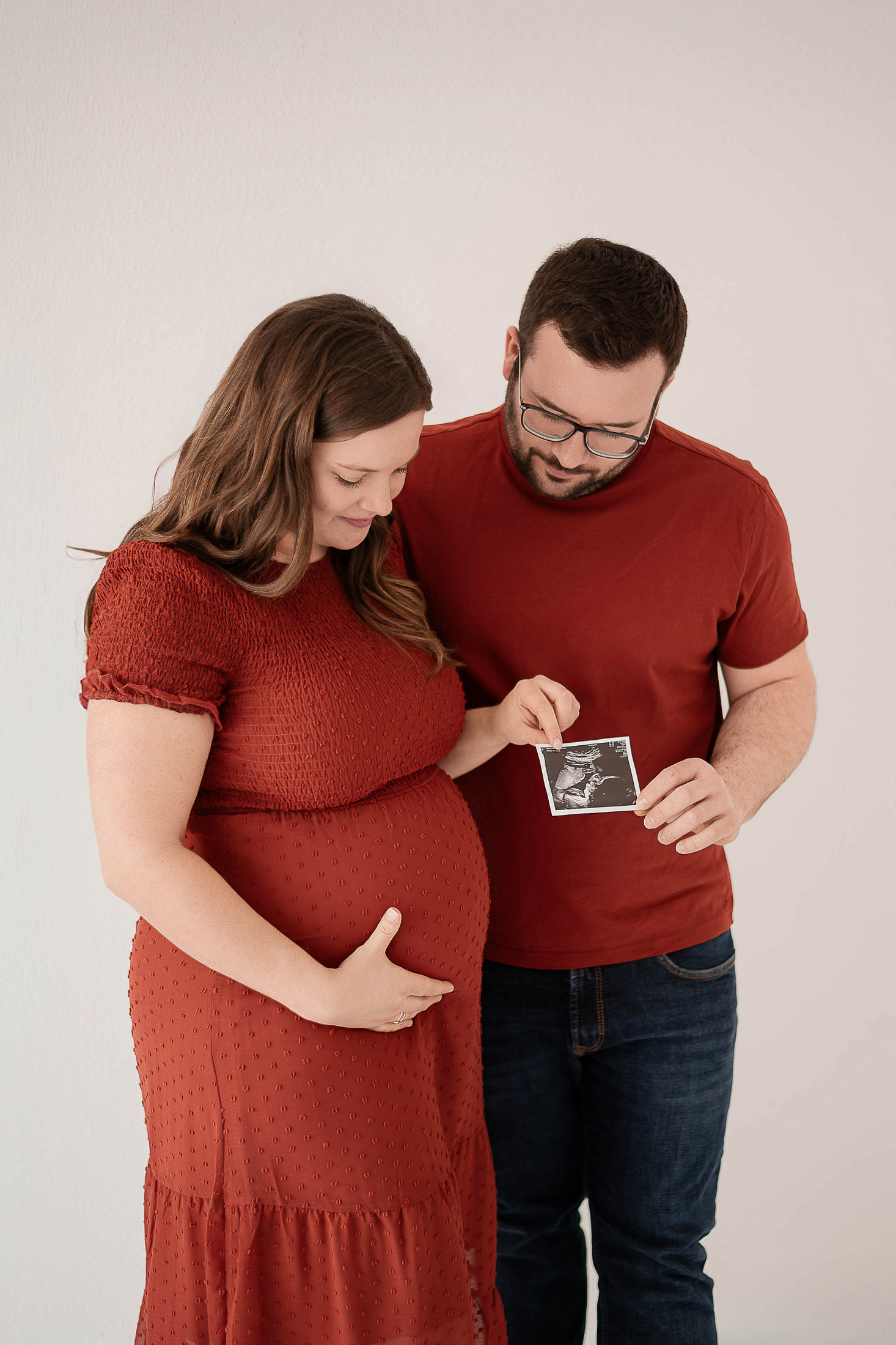 Schwangeres Paar betrachtet gemeinsam das Ultraschallbild ihres Babys