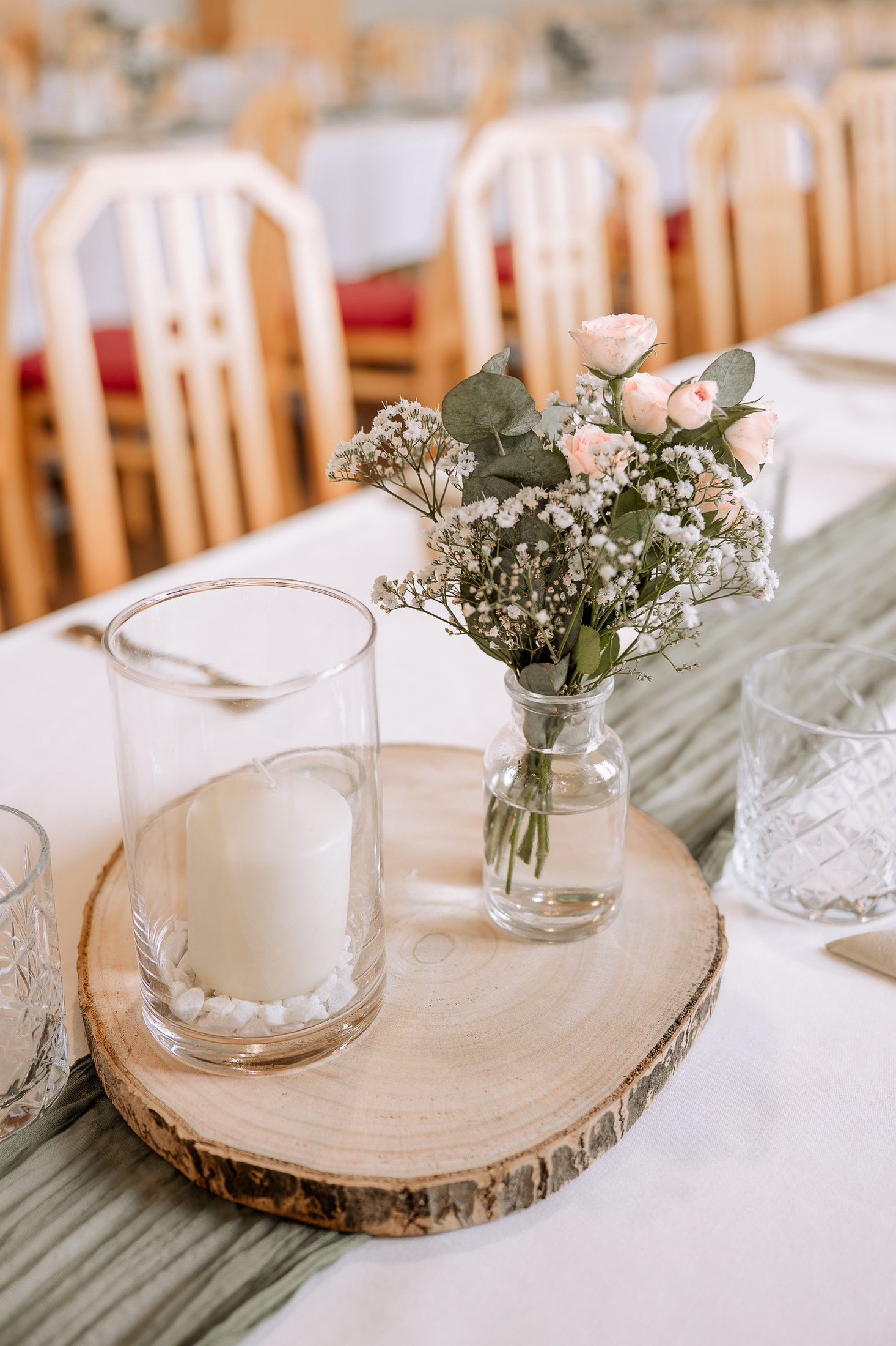 Tischdekoration mit Blumen und Kerze im Gasthof