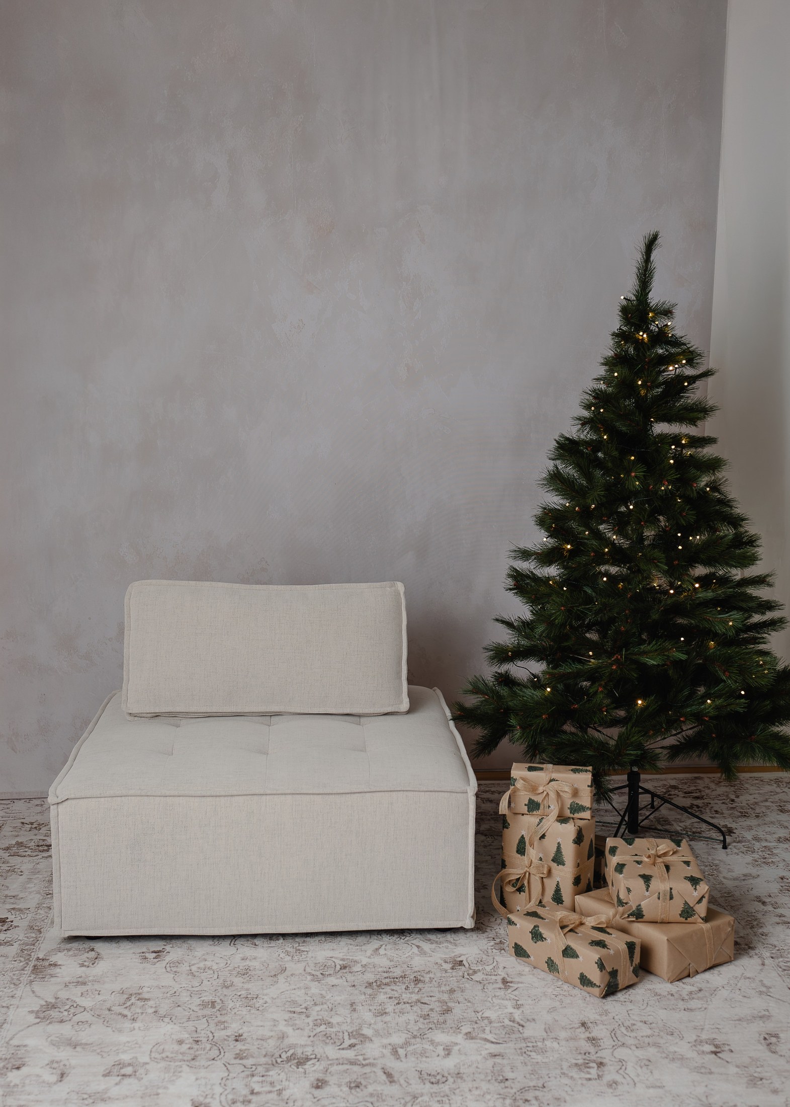 Weihnachtskulisse mit Weihnachtsbaum, Geschenken und hellem Sessel