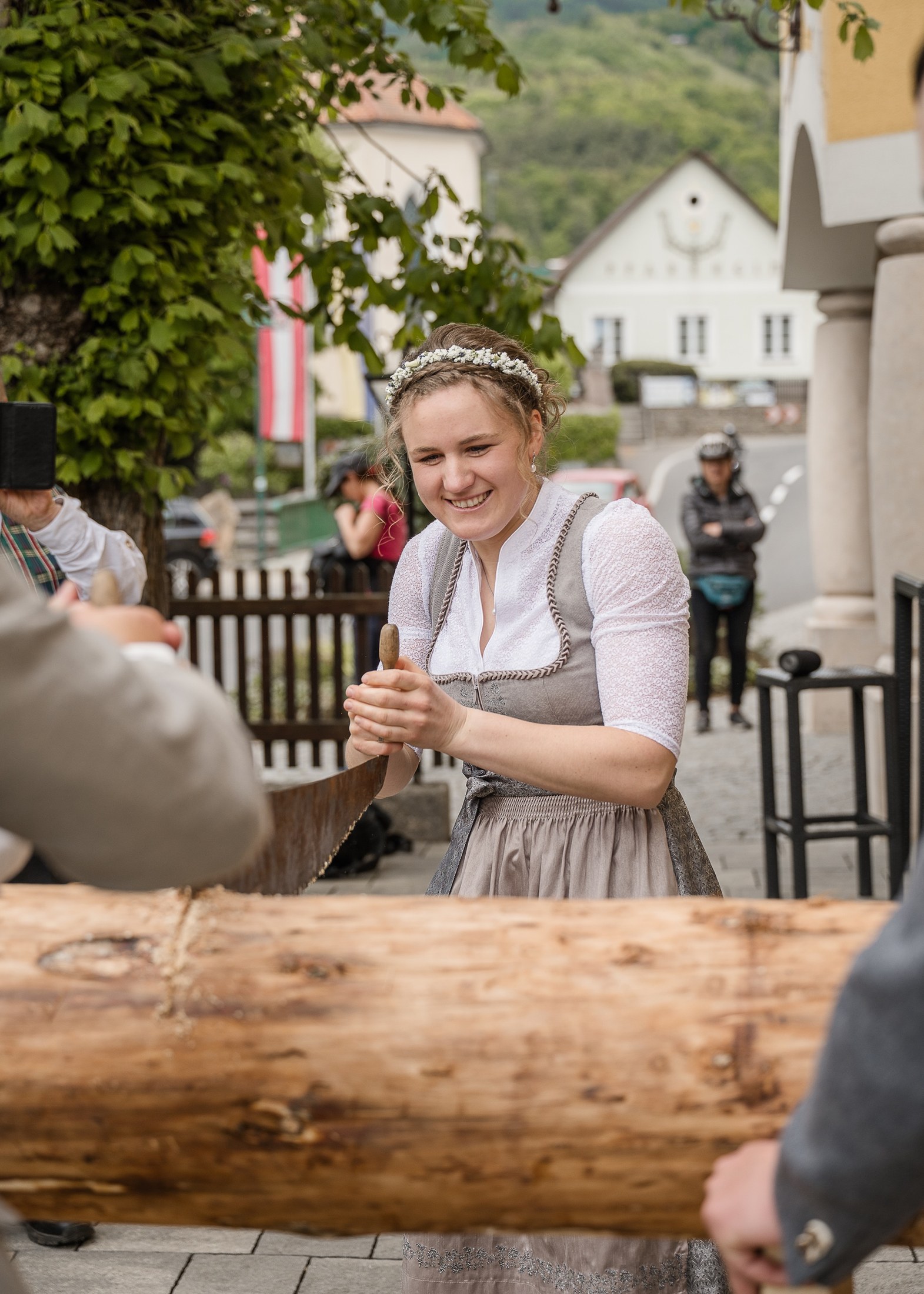 Braut sägt lachend den Baumstamm